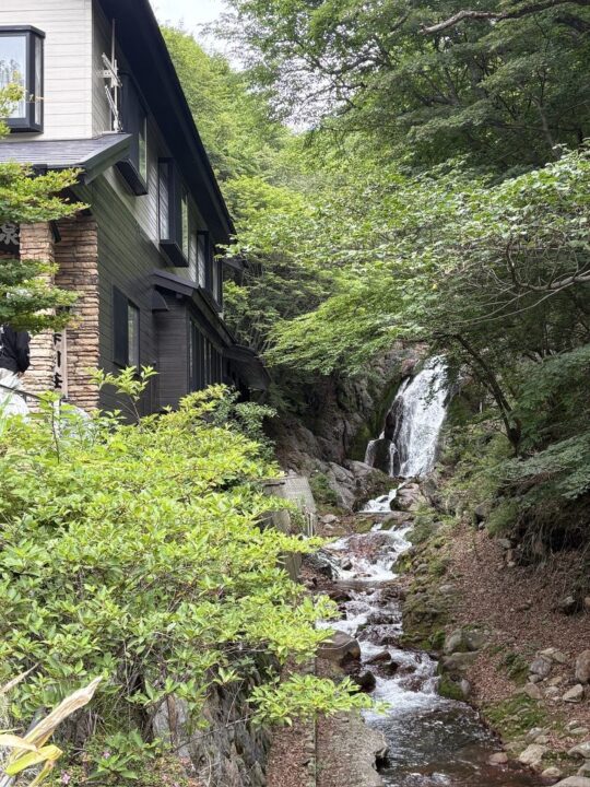 赤川温泉の建物横を流れる滝の風景