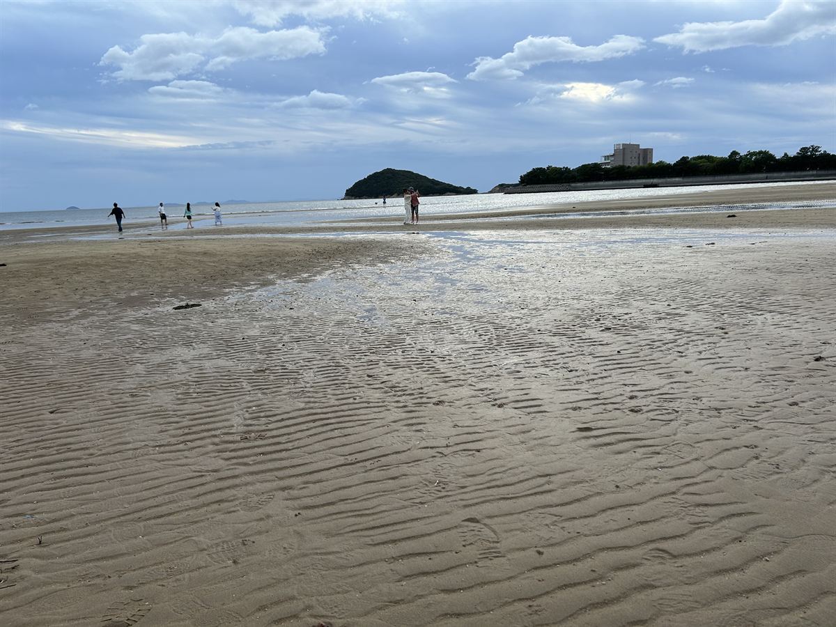 干潮時の父母ヶ浜を歩く観光客