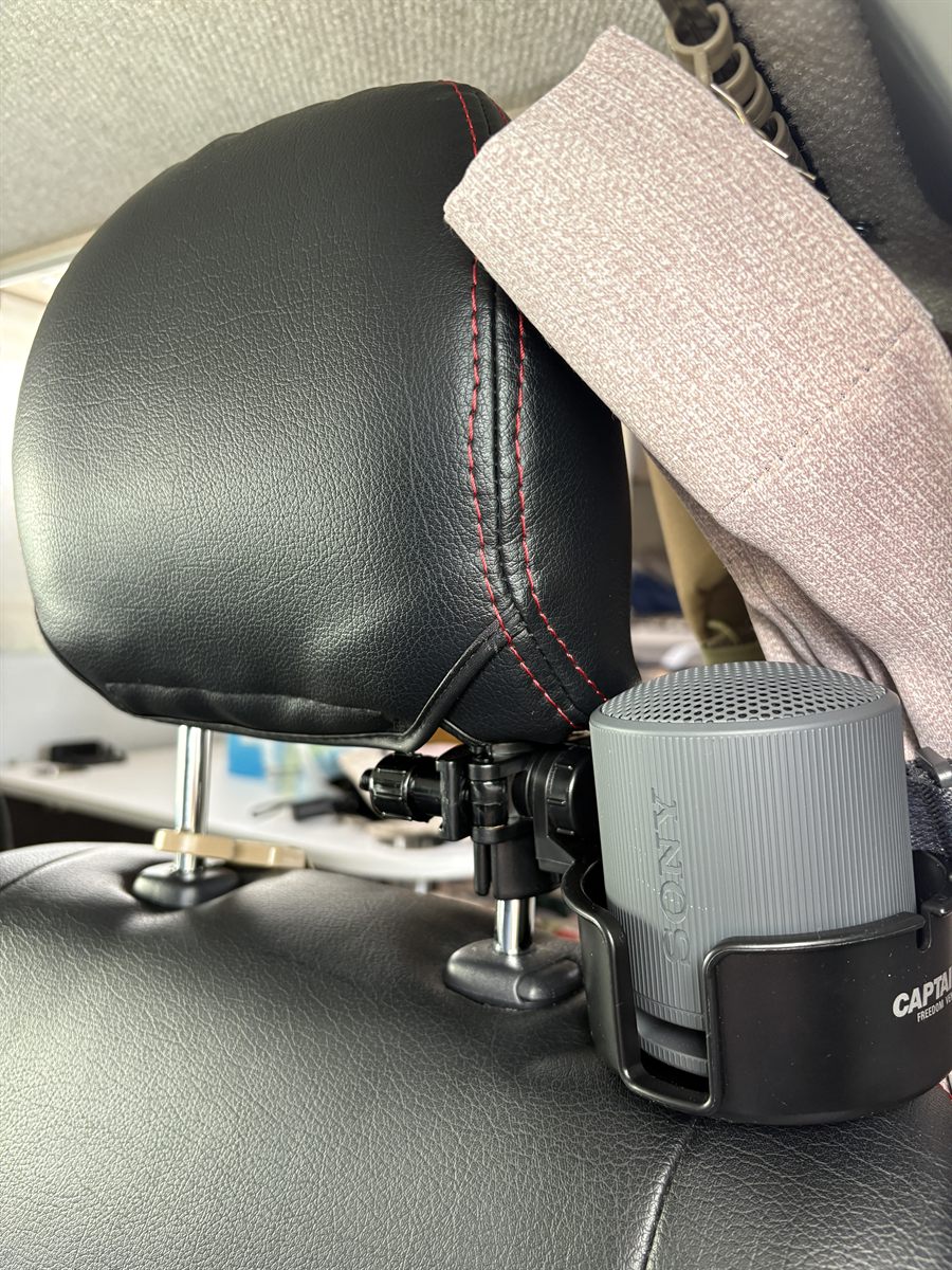 ヘッドレストに固定したドリンクホルダーに置いたソニーのワイヤレススピーカー