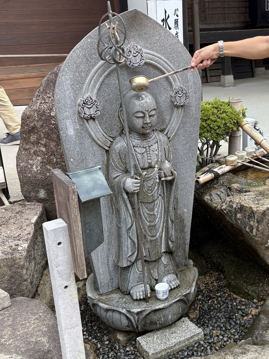 瑠璃光寺の水かけ地蔵に水をかける様子