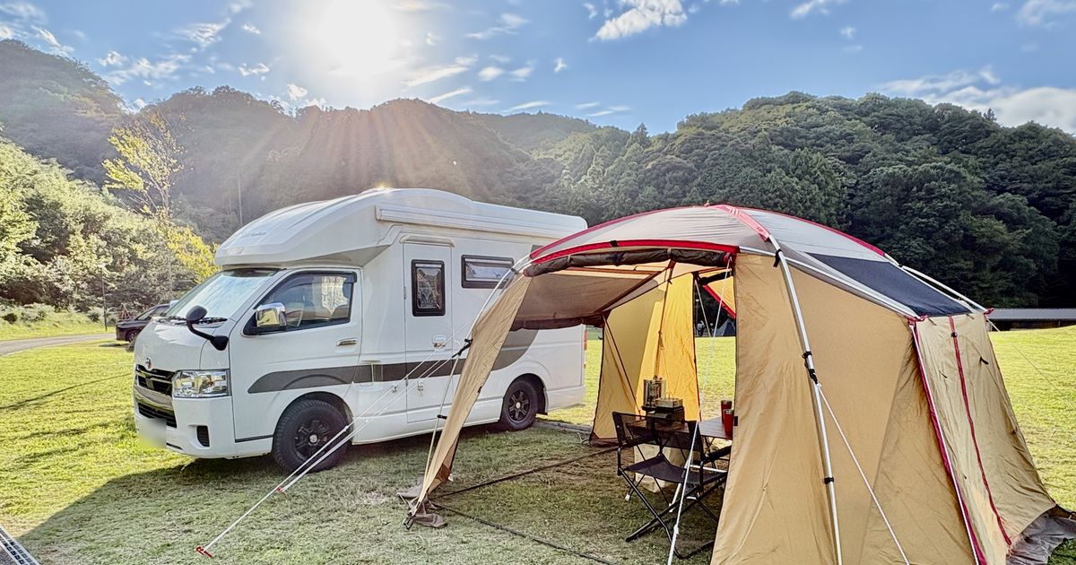 秋晴れのモンベル五ケ山ベースキャンプに停めたキャンピングカーとテント