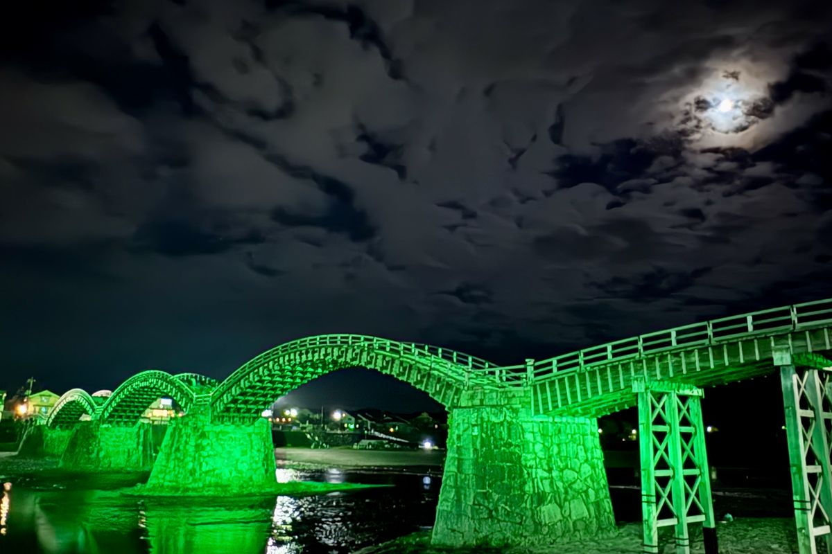 月明かりと緑のライトアップに照らされた夜の錦帯橋